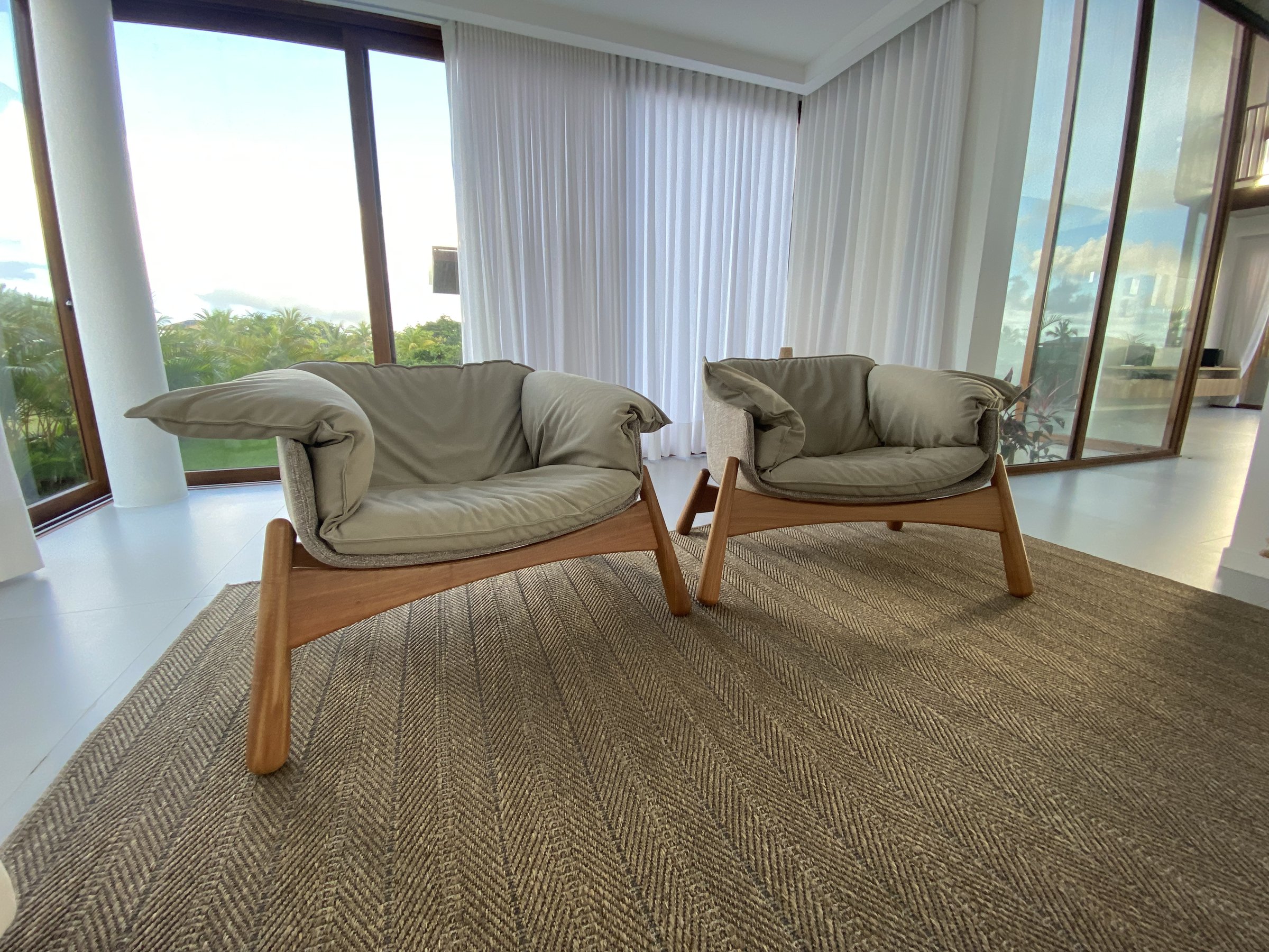 Sala de estar com poltronas e vista para o jardim